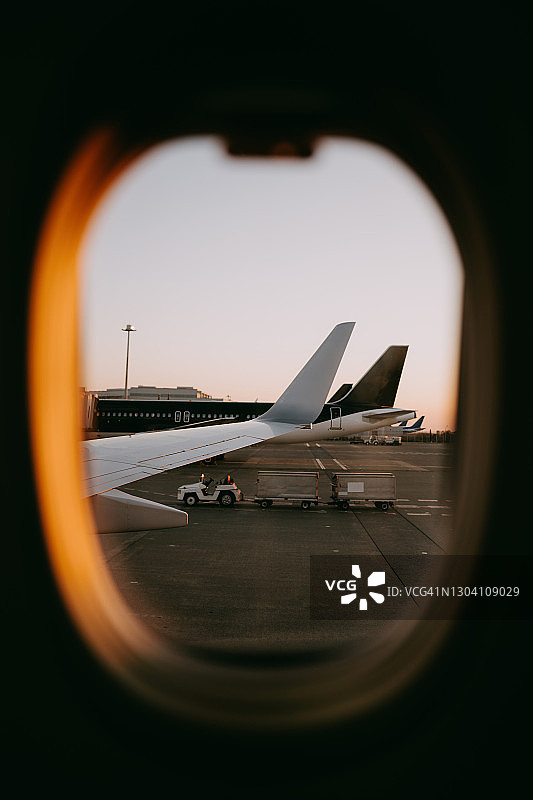 从飞机窗口看到的日出时机场的飞机图片素材