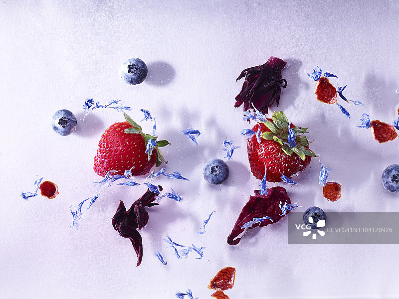 漂浮在水中的草莓、蓝莓、芙蓉、薰衣草和玫瑰果图片素材