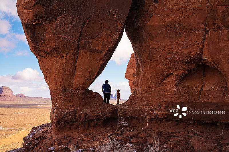亚利桑那州纪念碑谷的纳瓦霍兄弟站在泪珠拱门旁图片素材