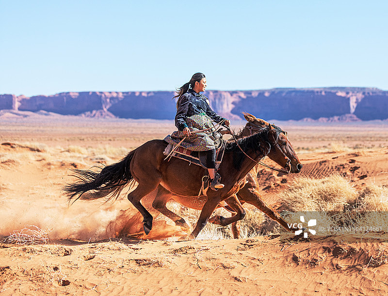 在美国亚利桑那州骑马的纳瓦霍姐妹图片素材