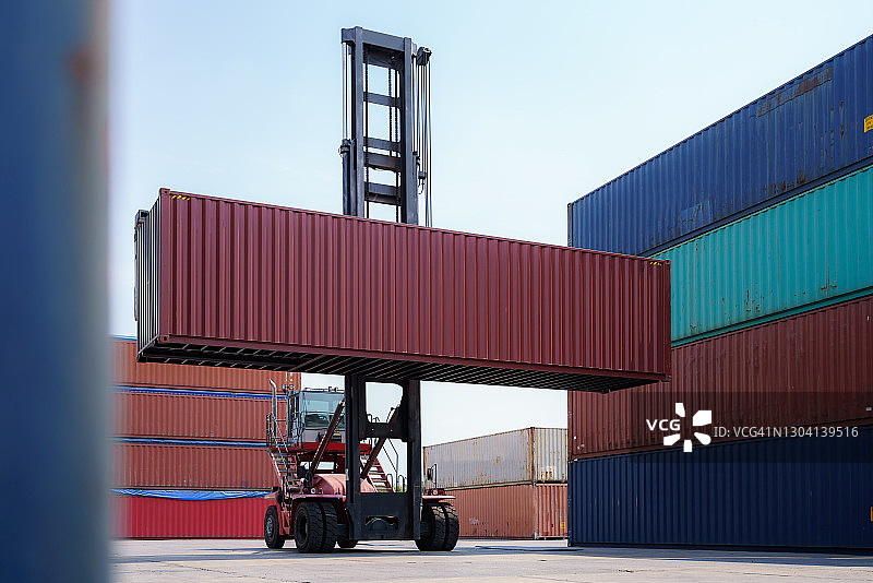 起重机或叉车在港口附近的货运码头起吊集装箱堆垛，物流行业或货运业务概念图片素材