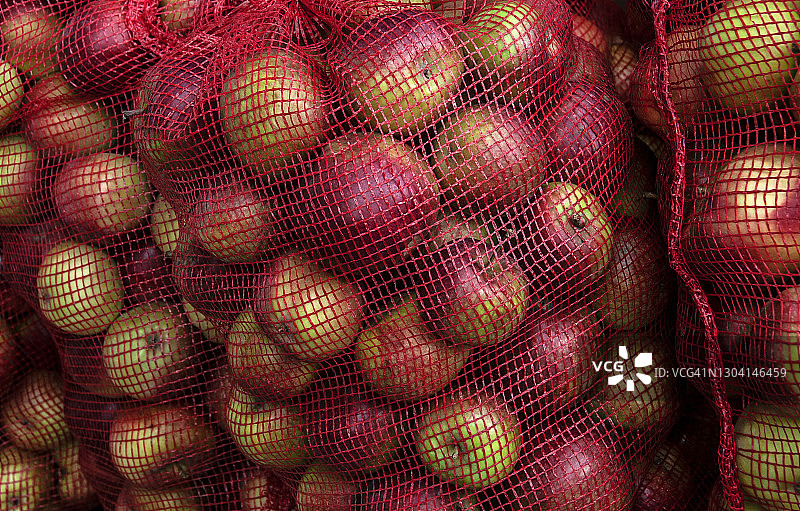 秋季出售的三个网袋装红色苹果图片素材