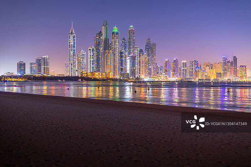 朱美拉棕榈岛的日落景色： Marina天际线和人造湖上未来主义摩天大楼图片素材