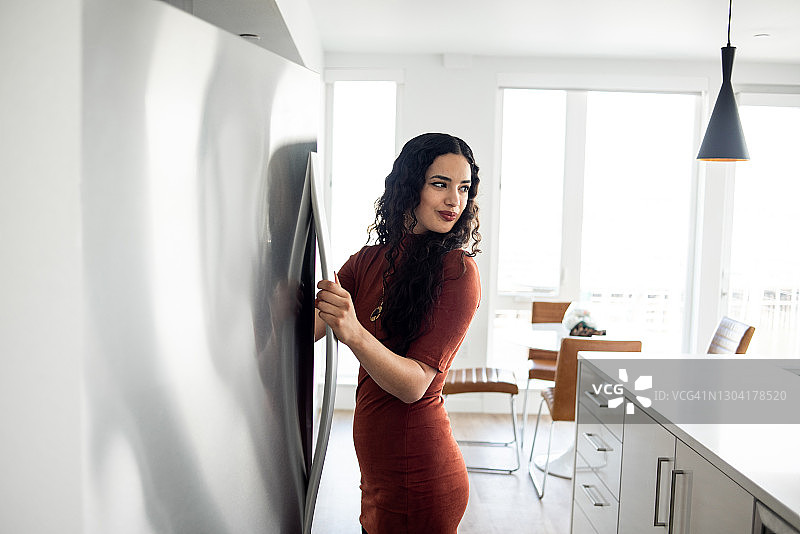 年轻女人打开冰箱拿东西图片素材