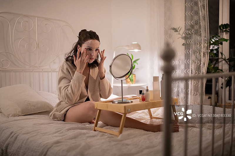 年轻女子在脸上涂抹保湿面膜图片素材