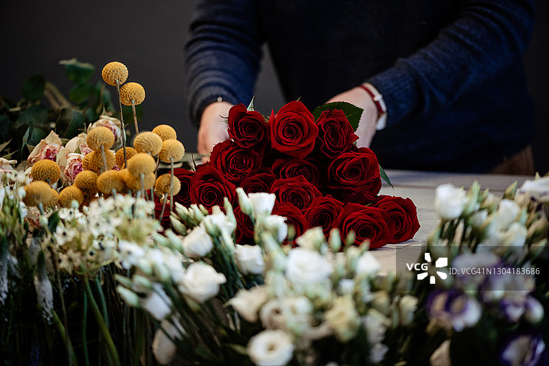 快乐的白人女花商为情人节制作和销售红玫瑰图片素材