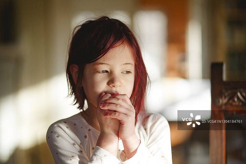 染着红发的害羞小女孩独自坐着图片素材