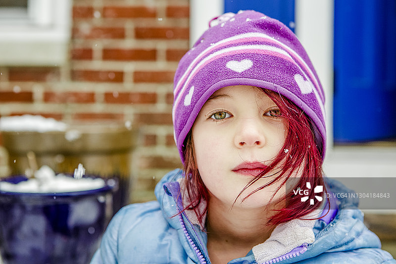 在冬天坐在户外的染着鲜红头发的可爱小女孩图片素材