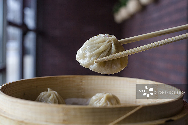 用筷子从蒸笼里夹汤包的特写图片素材