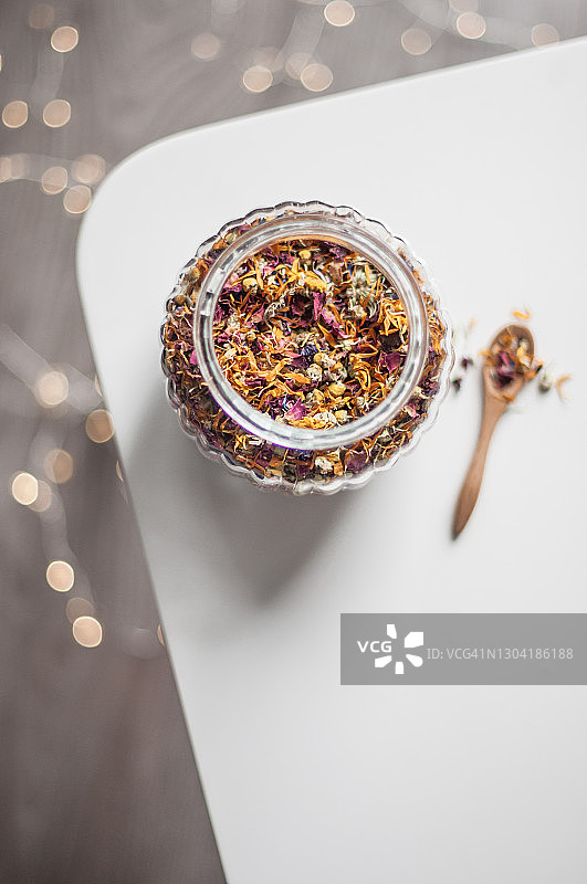 逆光下的干花茶玻璃罐与木勺图片素材