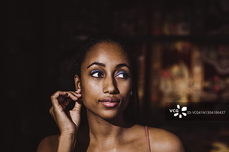 在家中触摸耳垂的年轻女子图片素材