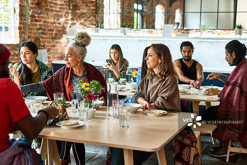 在餐厅享用午餐的多元种族瑜伽学生图片素材