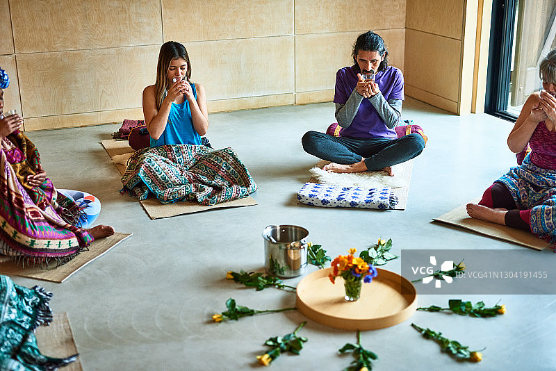瑜伽馆内，瑜伽团体在仪式中饮茶图片素材
