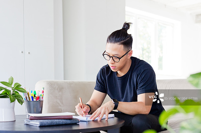 在创意工作场所做笔记的年轻设计师图片素材