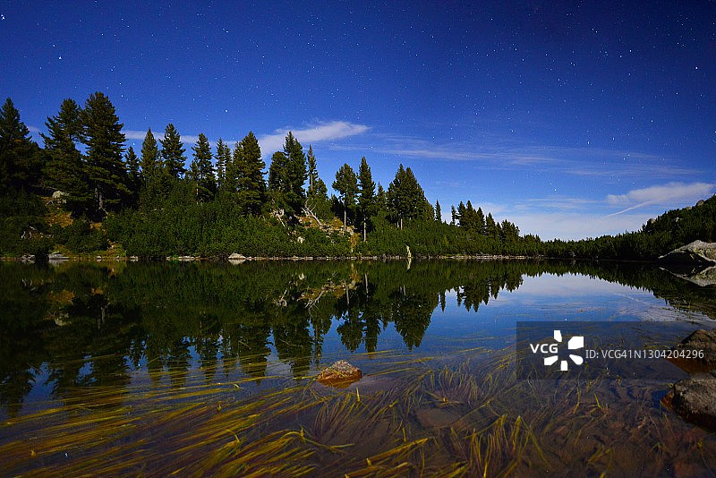 满月光下的松树山间湖泊图片素材