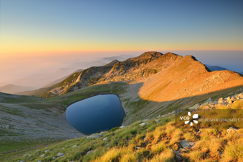 山顶上冰川湖日出时的田园风光图片素材