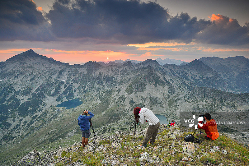 摄影师在山顶拍摄日落美景图片素材