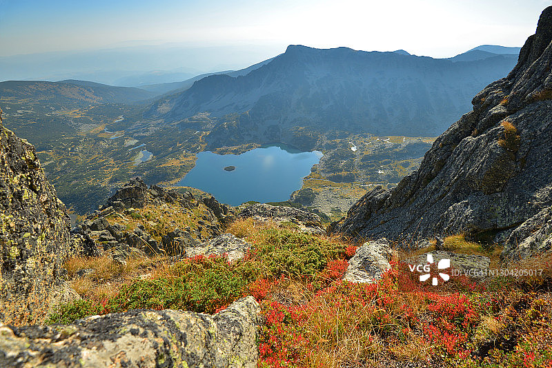 山顶上的晴天，可俯瞰蓝莓草甸和冰川湖图片素材