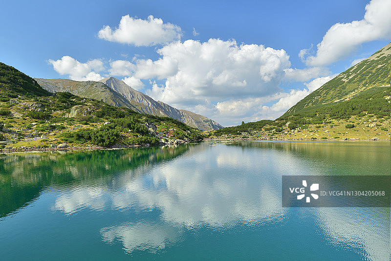 阳光明媚，山间湖畔的朵朵白云图片素材