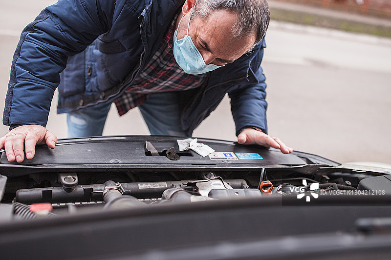 男子检查一辆坏车图片素材