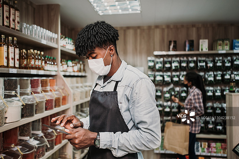 疫情期间营业的商店——两人佩戴防护口罩图片素材