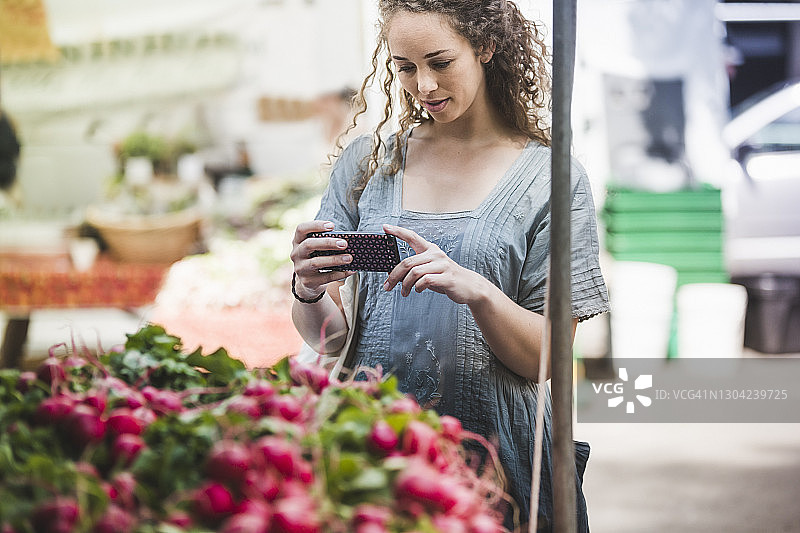 年轻女子在农贸市场拍摄蔬菜图片素材