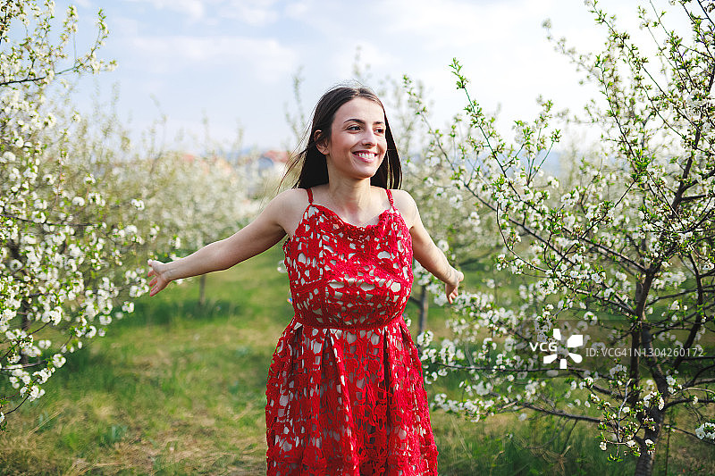 在盛开的树木中的年轻女人图片素材