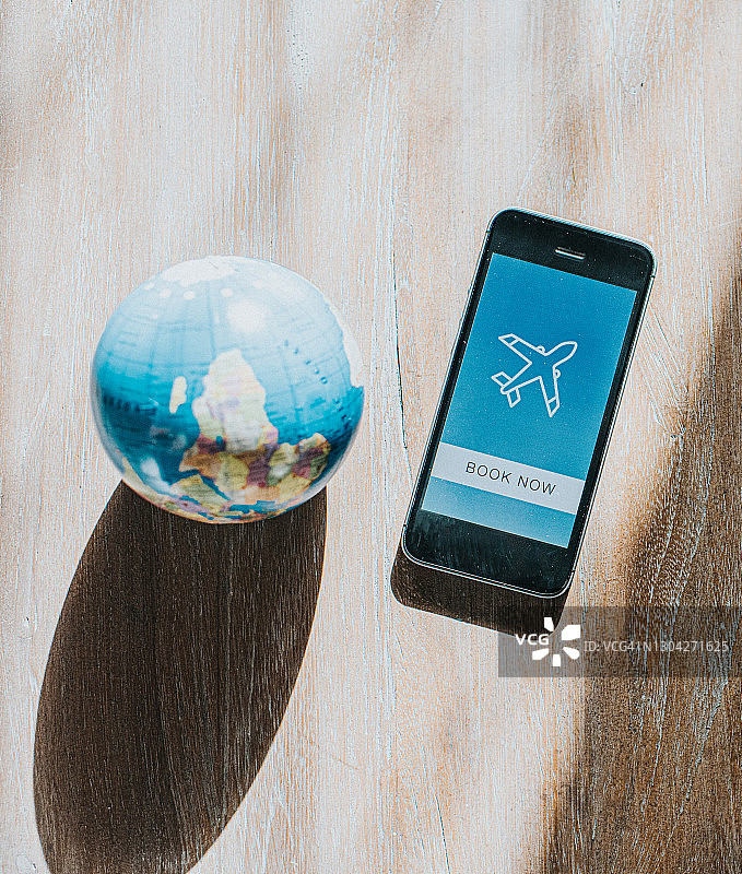 地球旁显示机票预订应用程序的手机图片素材