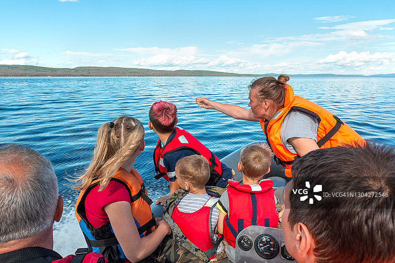 一家四口在湖上乘坐充气艇的水上之旅图片素材