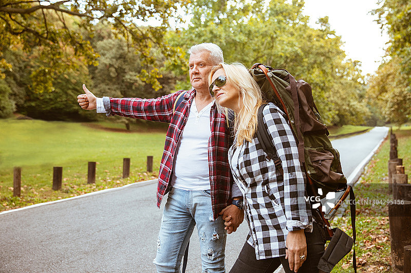 一对中年夫妇正在搭便车旅行图片素材