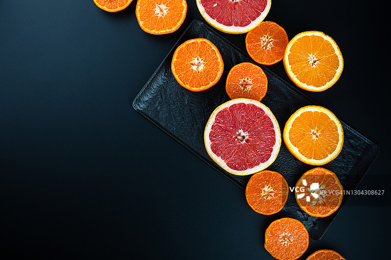 黑色背景上的橙子、橘子和葡萄柚图片素材