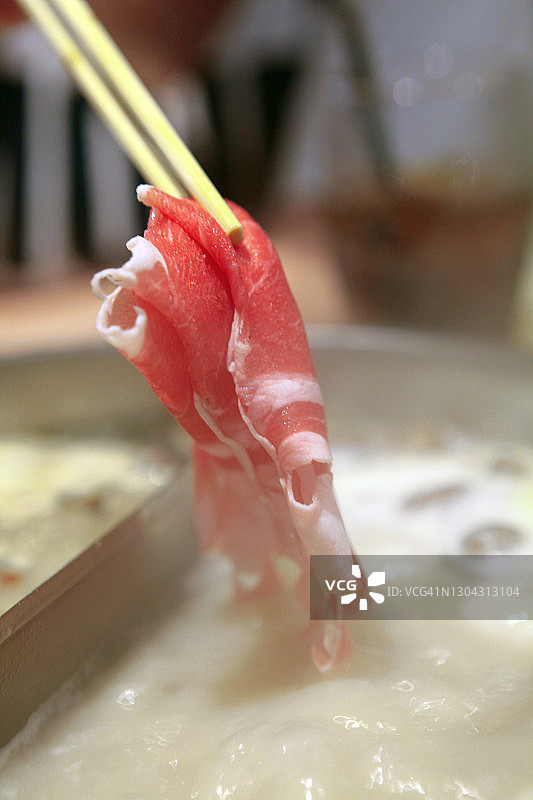 将切好的羊肉放入火锅中涮图片素材