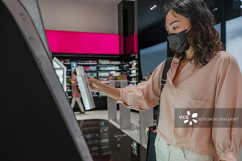 在美妆店购买止汗香体喷雾的印度尼西亚女性图片素材