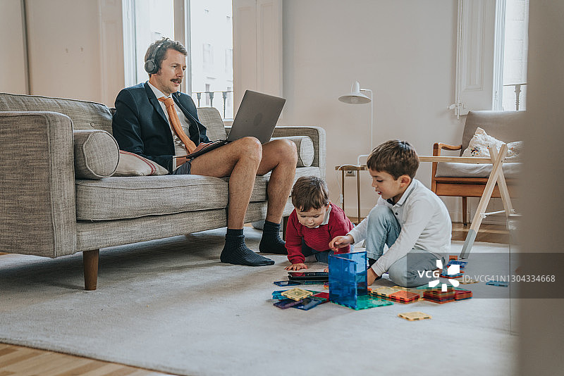 穿着夹克没穿裤子使用笔记本电脑的商人图片素材