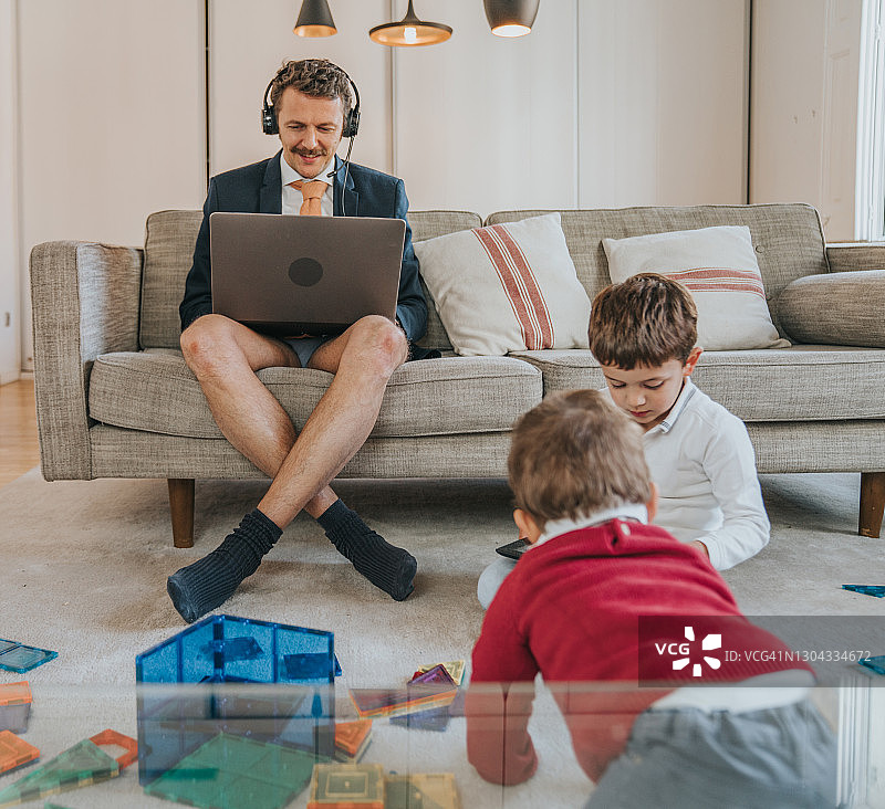 穿着夹克没穿裤子使用笔记本电脑的商人图片素材