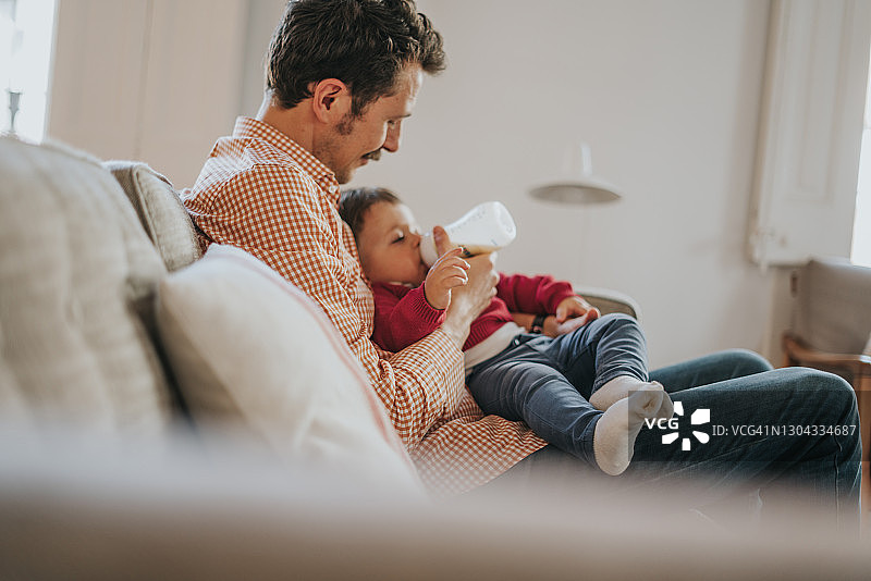 父亲用奶瓶喂宝宝图片素材