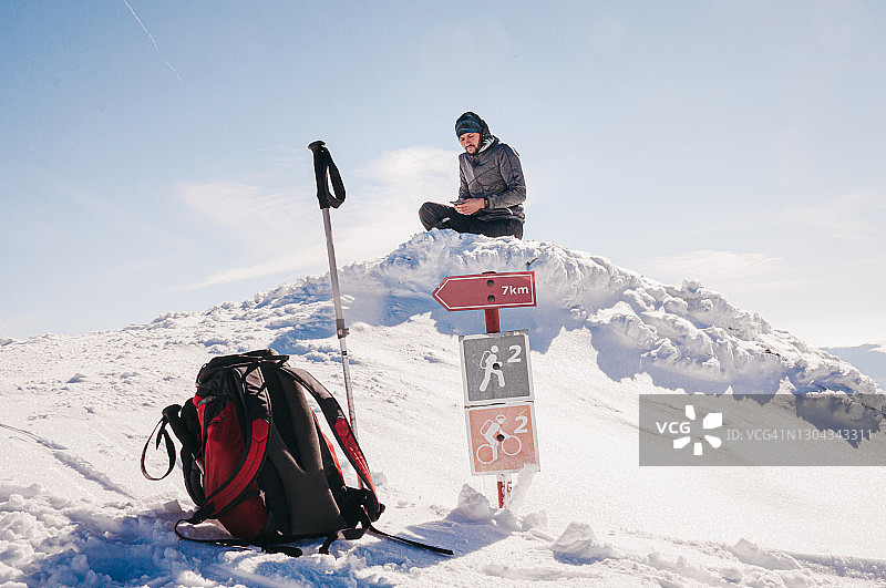 坐在指示牌旁边的成年徒步男子图片素材
