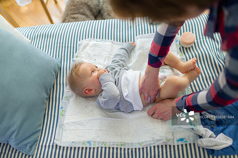 母亲给宝宝换尿布图片素材