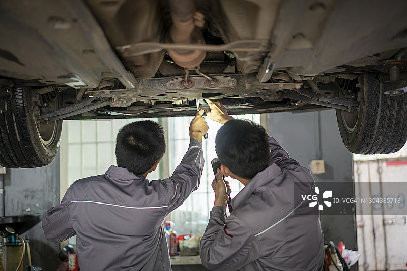 两名年轻技术人员正在修理汽车图片素材