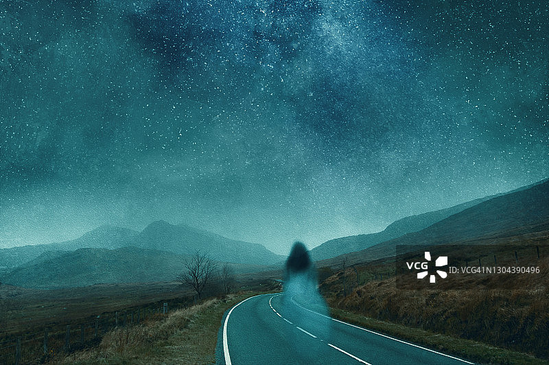 幽灵般透明女人漂浮山路夜景。图片素材