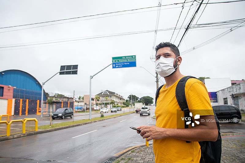 戴口罩等出租车的男学生图片素材