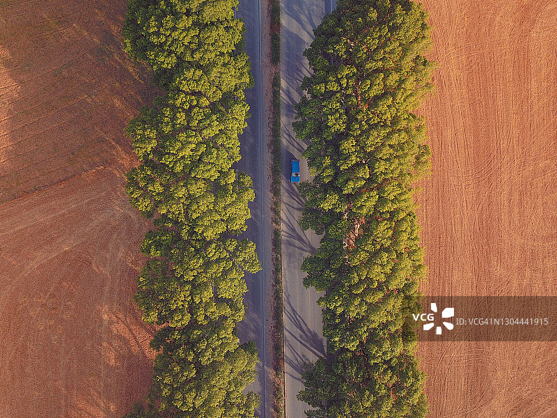 蓝色汽车在乡村道路上行驶的航拍图片素材