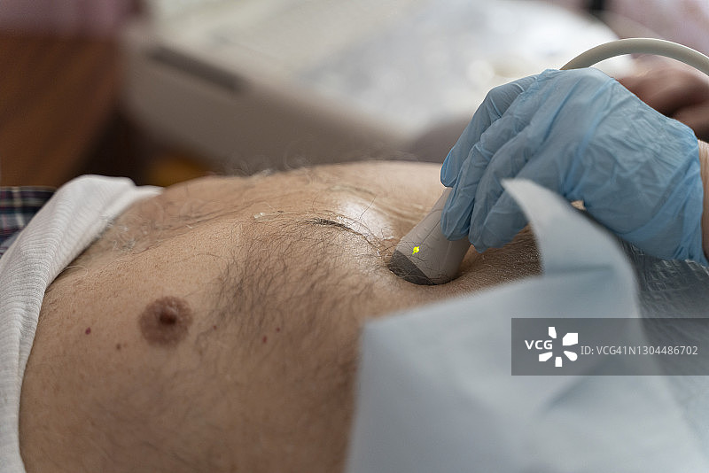 护士在家为97岁男性老人进行便携式超声检查图片素材