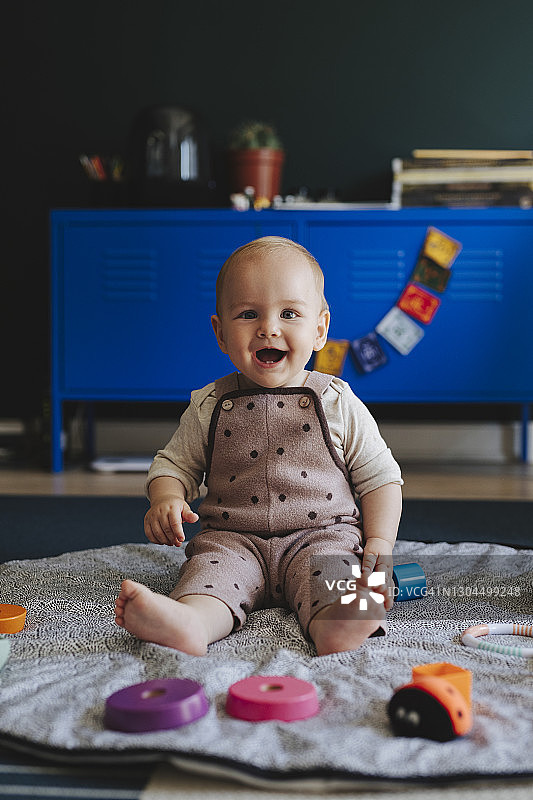 一个在家玩玩具的可爱微笑女婴图片素材