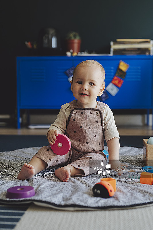 一个在家玩玩具的可爱微笑女婴图片素材