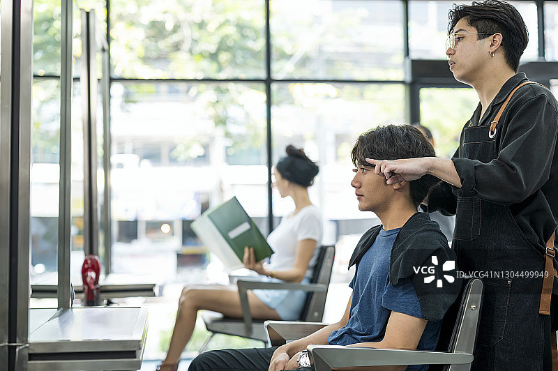 理发店内，理发师与顾客讨论发型图片素材