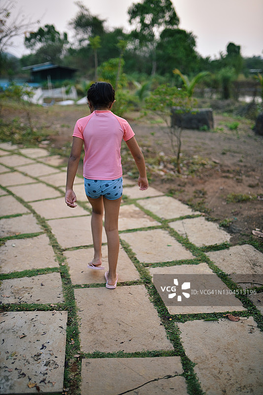 走在草地砖人行道上的女孩肖像图片素材