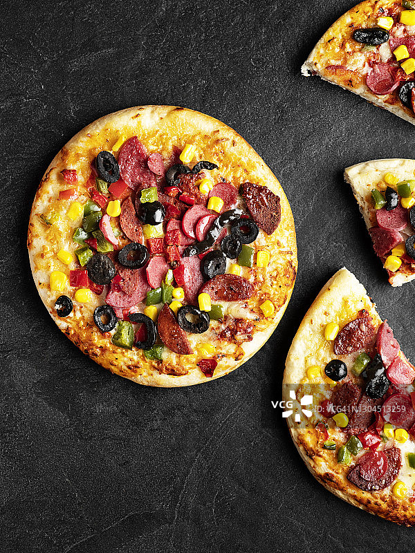 辣香肠披萨配萨拉米、橄榄和玉米图片素材