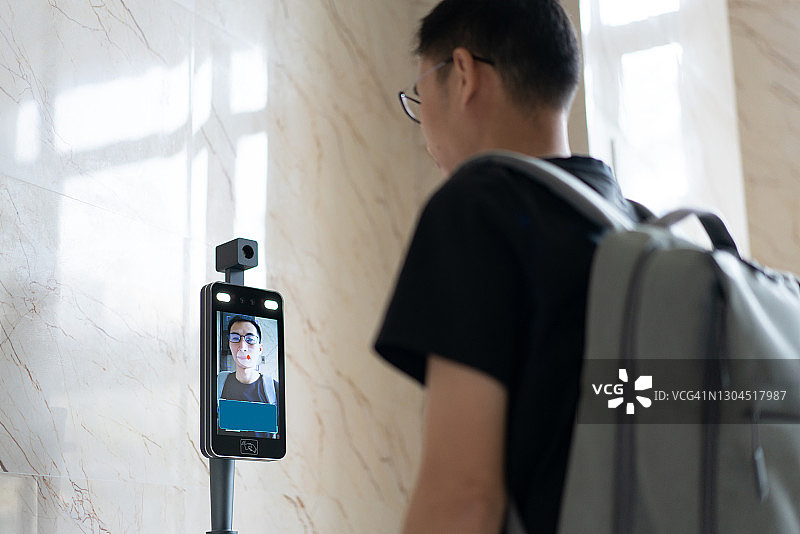 亚洲男子使用红外考勤机图片素材