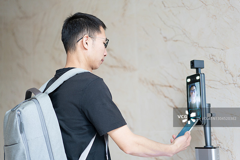 亚洲男子使用红外考勤机图片素材